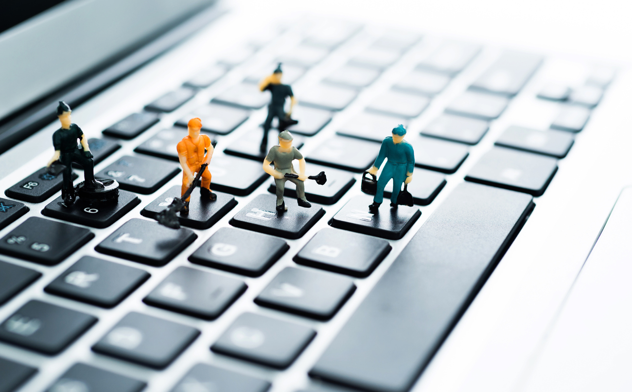 A group of figurines cleaning computer keyboard